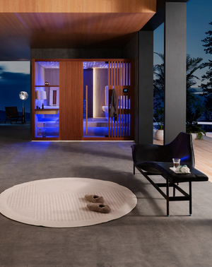 A luxury indoor sauna featuring warm wooden panels, a star-lit ceiling, and soothing blue ambient light, complemented by a minimalist relaxation area with a sleek black bench and soft slippers — a serene modern wellness space that embodies Haus of Heat’s balance of design, comfort, and calm.