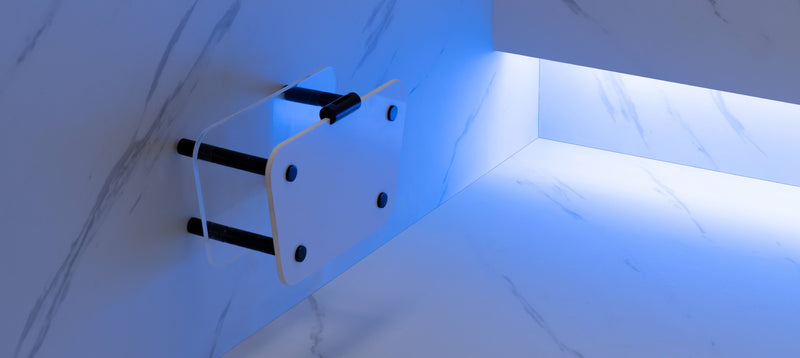 Wall-mounted bracket with LED light on a white marble wall steam