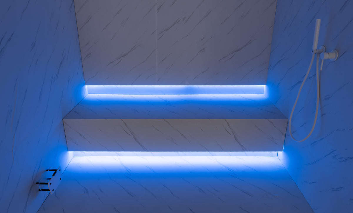 Modern steam room with illuminated steps and marble walls