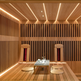 Load image into Gallery viewer, Novo sauna in ash and hemlock wood with grid design and warm lighting.
