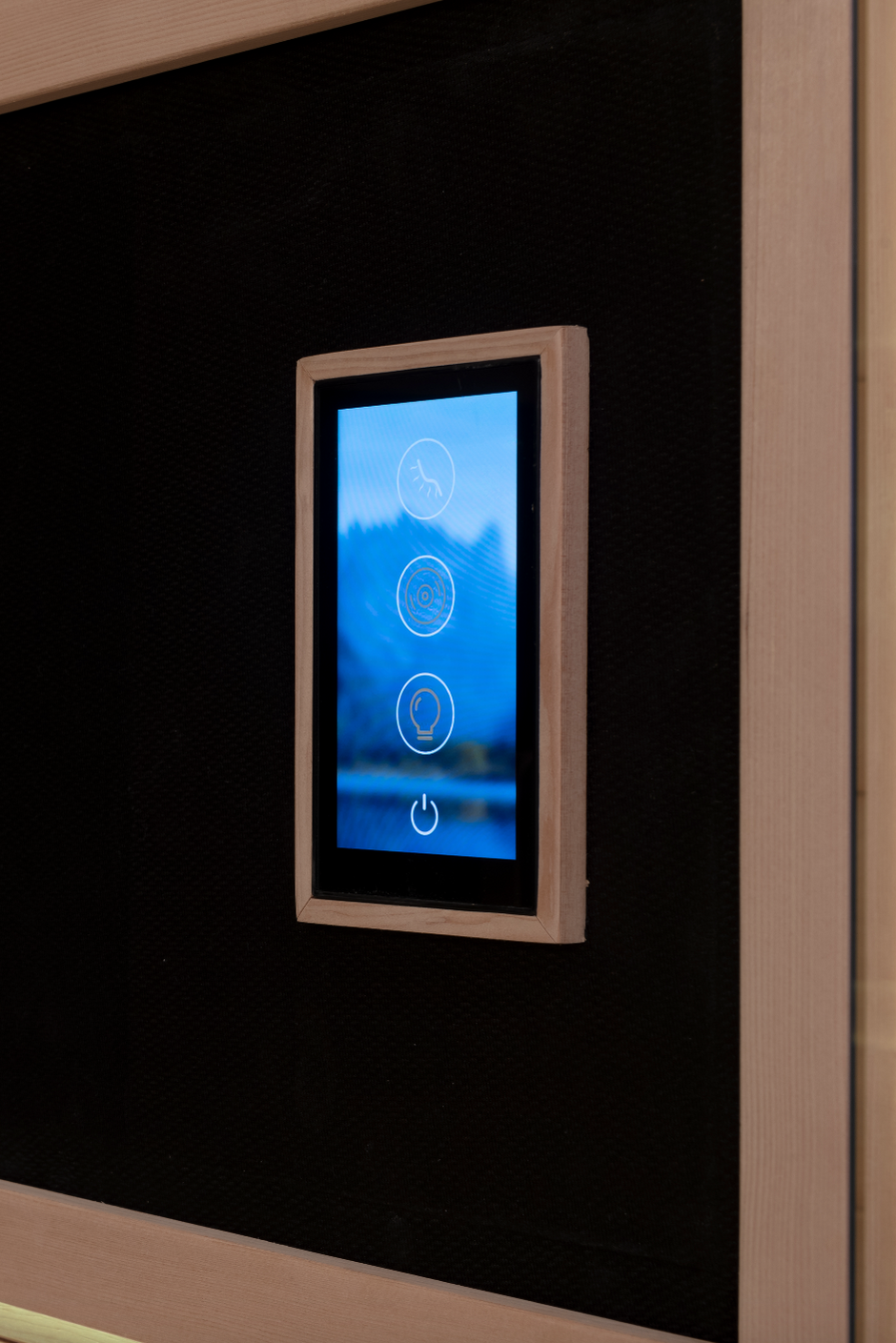 Touchscreen control panel on a black wall with illuminated baseboard