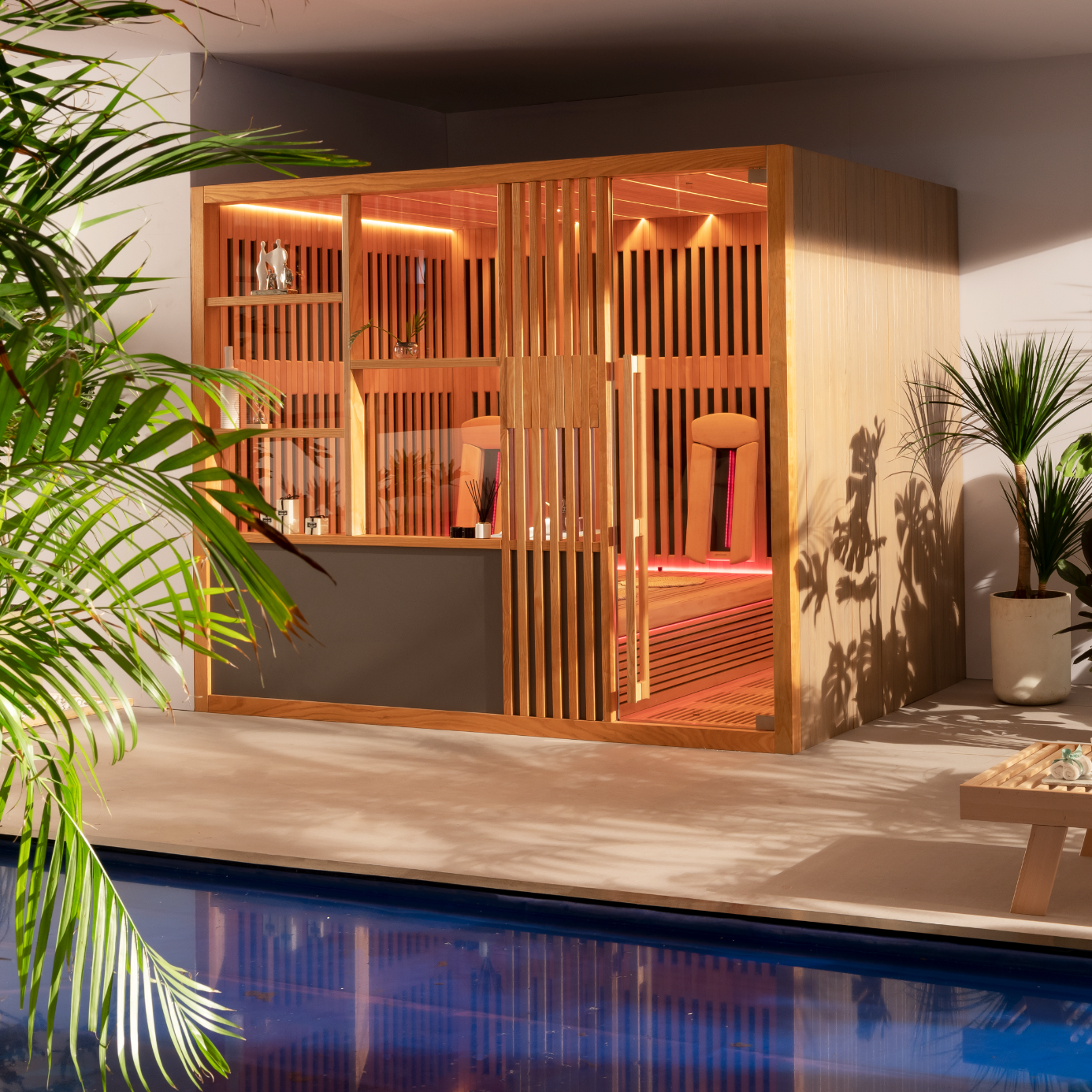 Wooden sauna structure by a pool with plants around